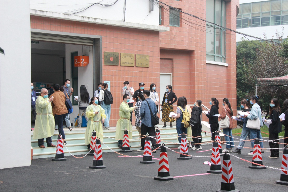 图为考生进入考场前,工作人员做好体温测量工作 图为考生进入考场前,工作人员做好体温测量工作
