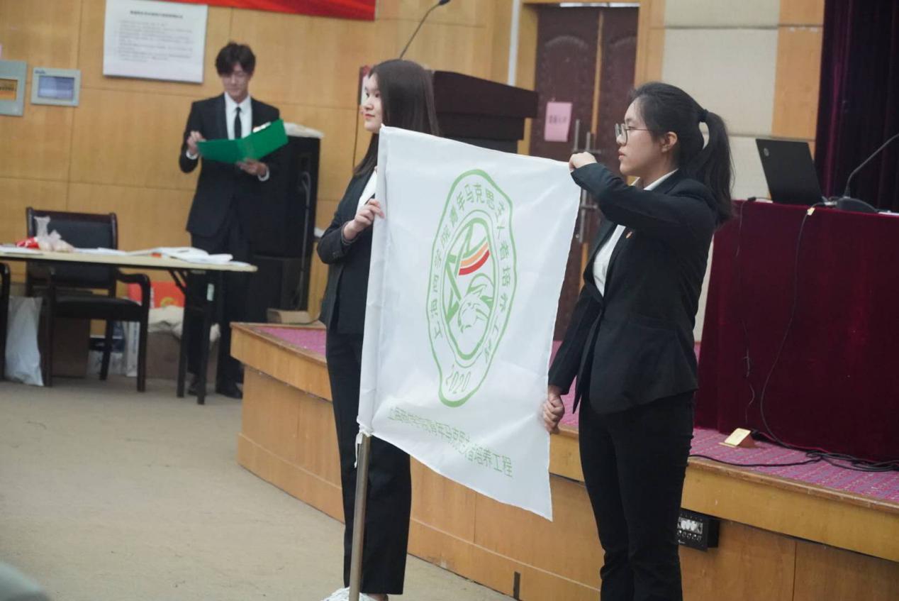 图为优秀学员代表黄嘉琦为新学员代表吴亦荻授旗 图为优秀学员代表黄嘉琦为新学员代表吴亦荻授旗