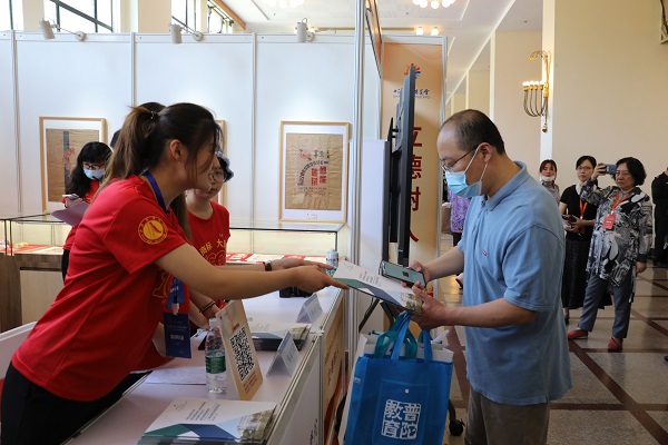 图为志愿者为参观者发放宣传材料 图为志愿者为参观者发放宣传材料