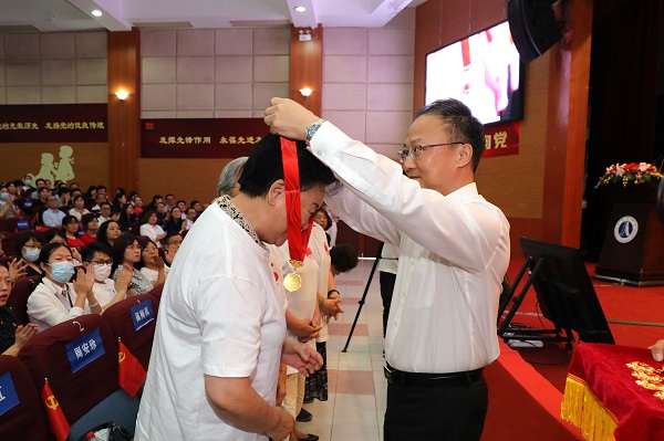 图为沈大明为光荣在党50年老党员佩戴“光荣在党50年”纪念章 图为沈大明为光荣在党50年老党员佩戴“光荣在党50年”纪念章