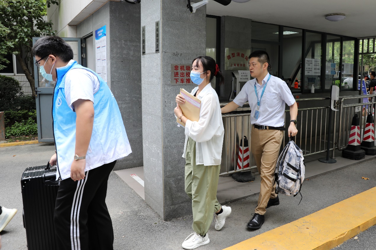 图为“上商青年”志愿者帮助新生进入校园 图为“上商青年”志愿者帮助新生进入校园