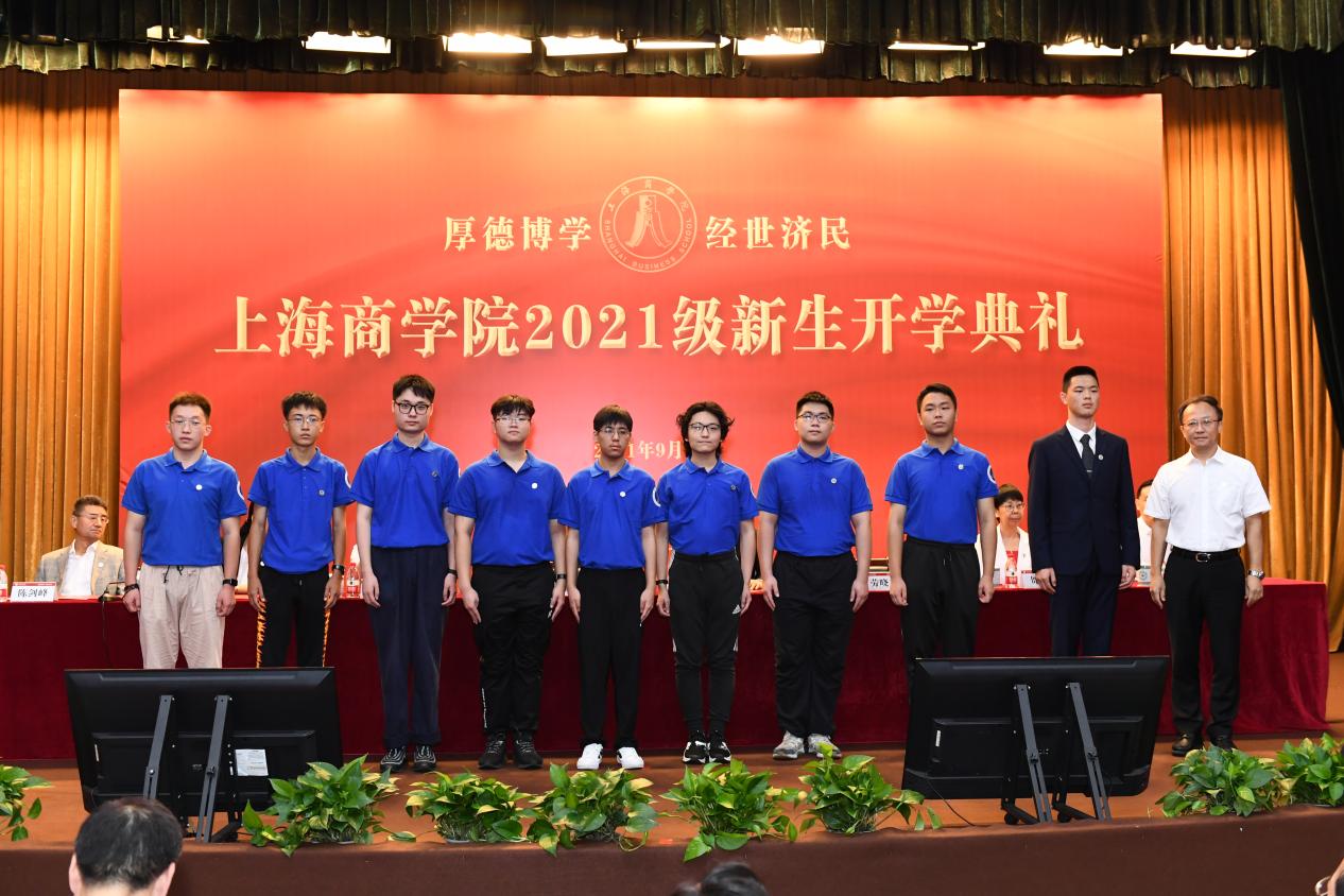 图为党委书记沈大明为新生代笔佩戴校徽 图为党委书记沈大明为新生代笔佩戴校徽